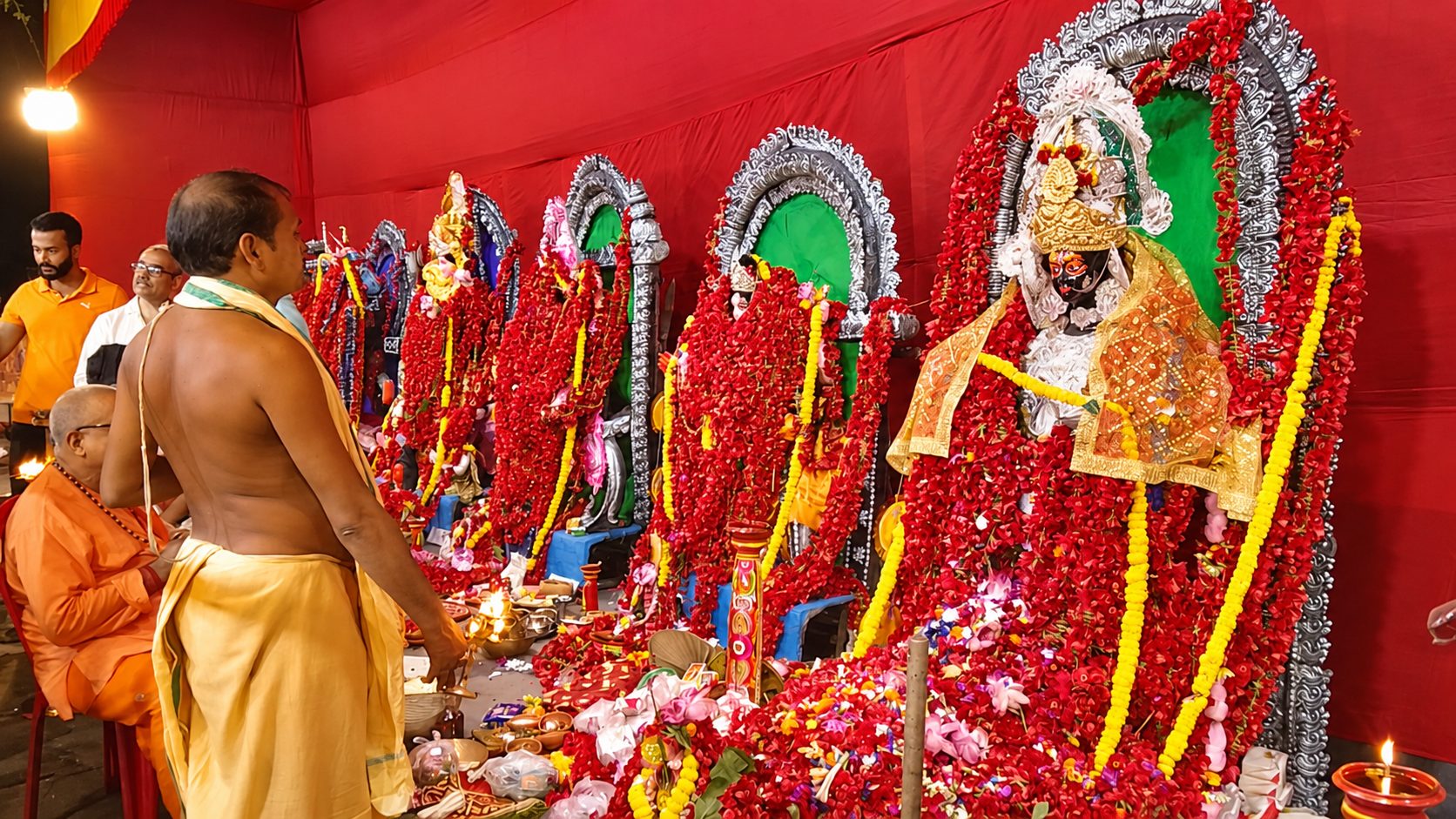 The Dasamahavidya altar at Chetla — the ten Mahavidyas adorned with red hibiscus garlands during the night of worship